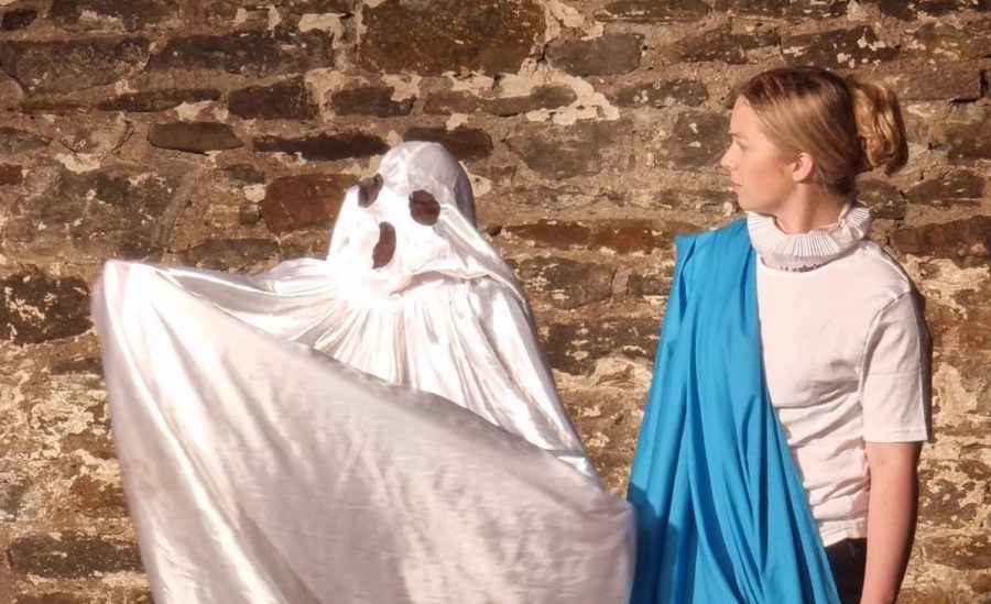 A woman in Roman dress looks quizzically at a ghost wearing a sheet on its head